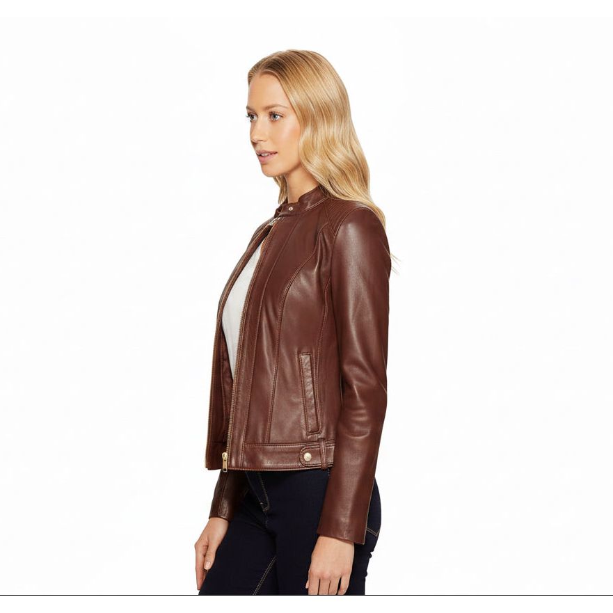 A blonde woman wearing a brown-leather moto jacket over a white top and black jeans, photographed against a solid white background.