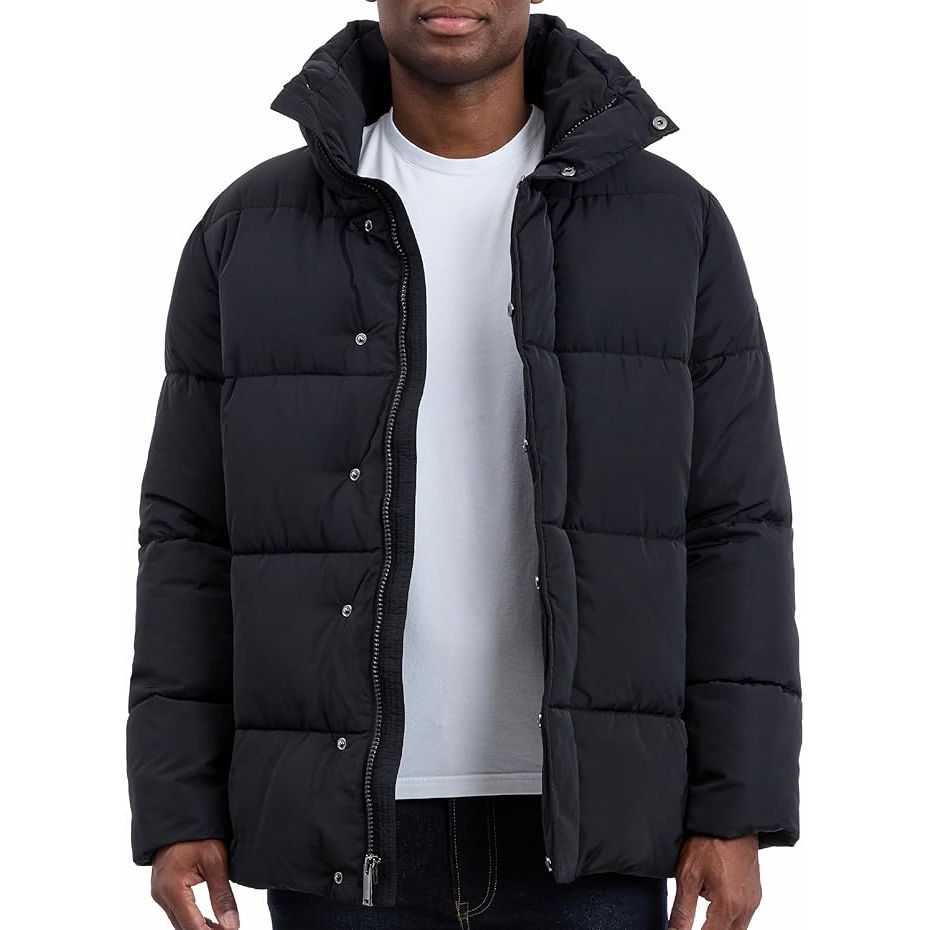 Person wearing a black puffer jacket over a white shirt on a white background