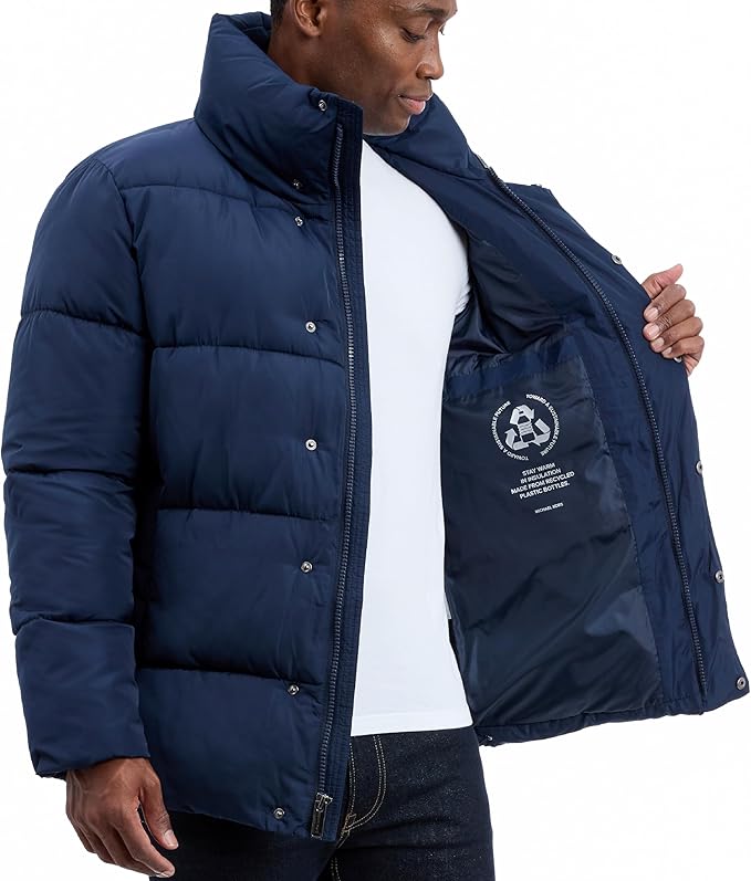 Man wearing a navy blue puffer jacket with a visible brand logo on a white background