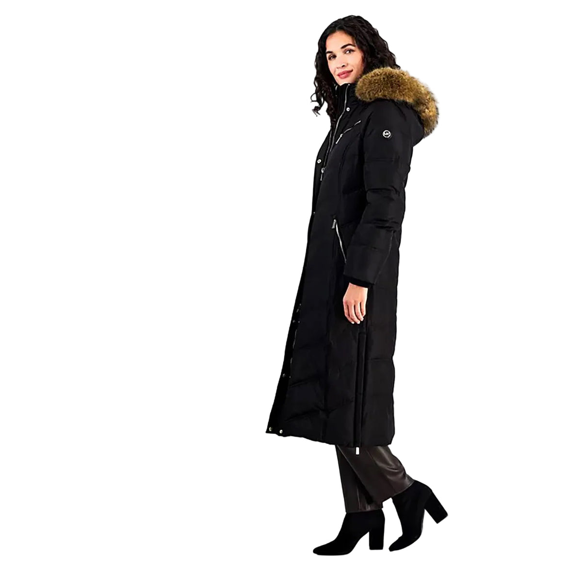 A woman modeling a long black puffer coat with a brown faux-fur trimmed hood, shown in profile against a plain white background.
