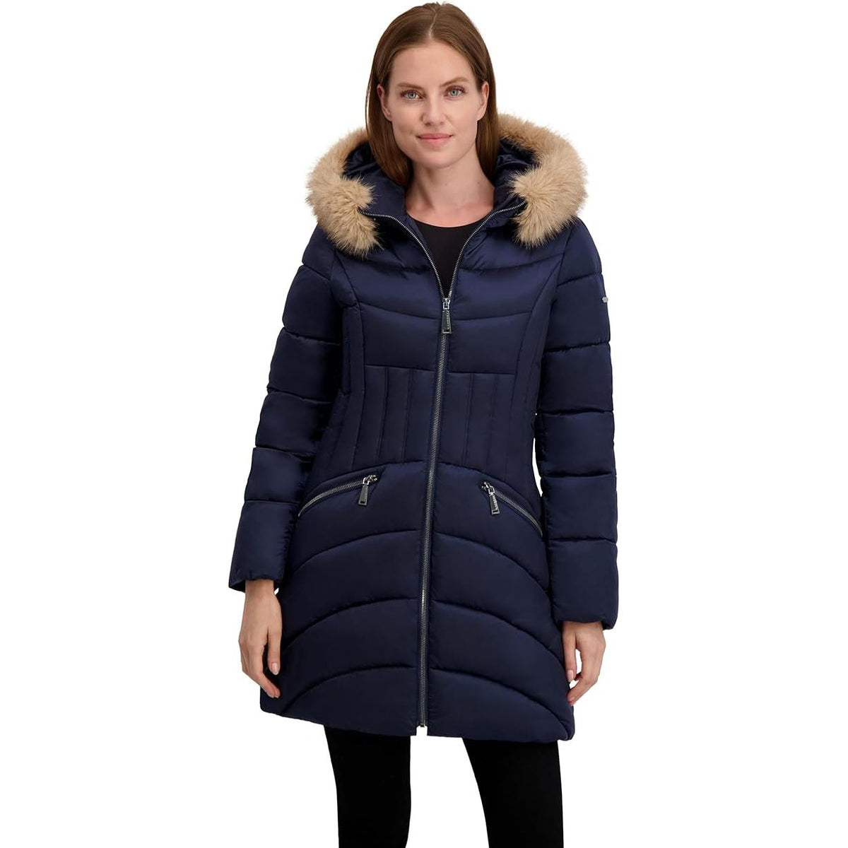 Woman wearing a navy blue puffer coat with fur hood on a white background