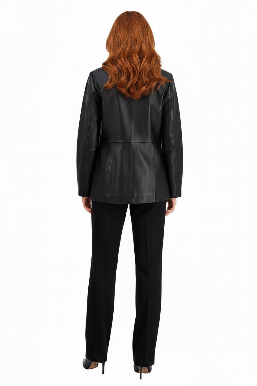 A woman shown from the back wearing a black structured leather jacket and black trousers against a light gray studio background.