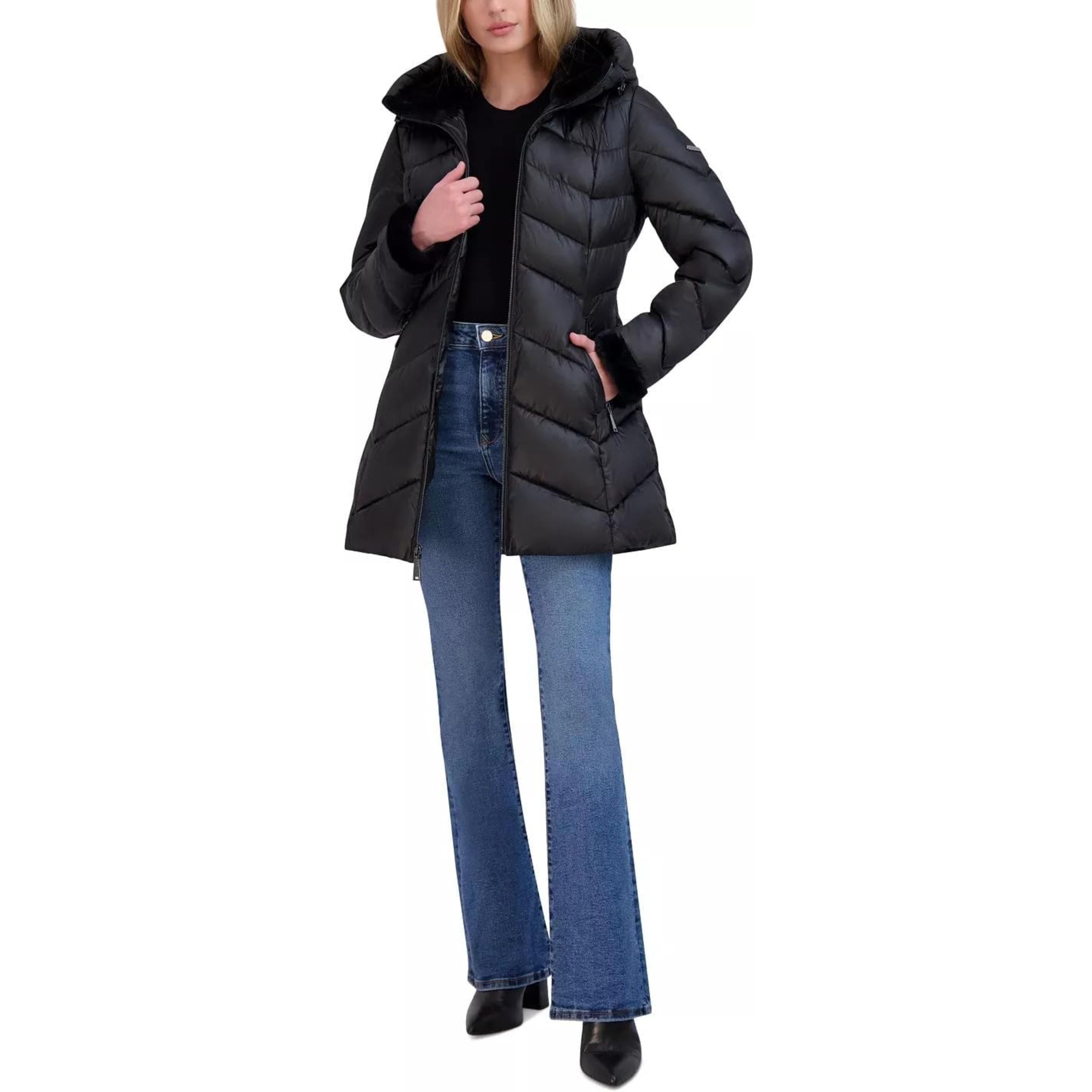 Person wearing a black puffer coat and blue jeans on a white background
