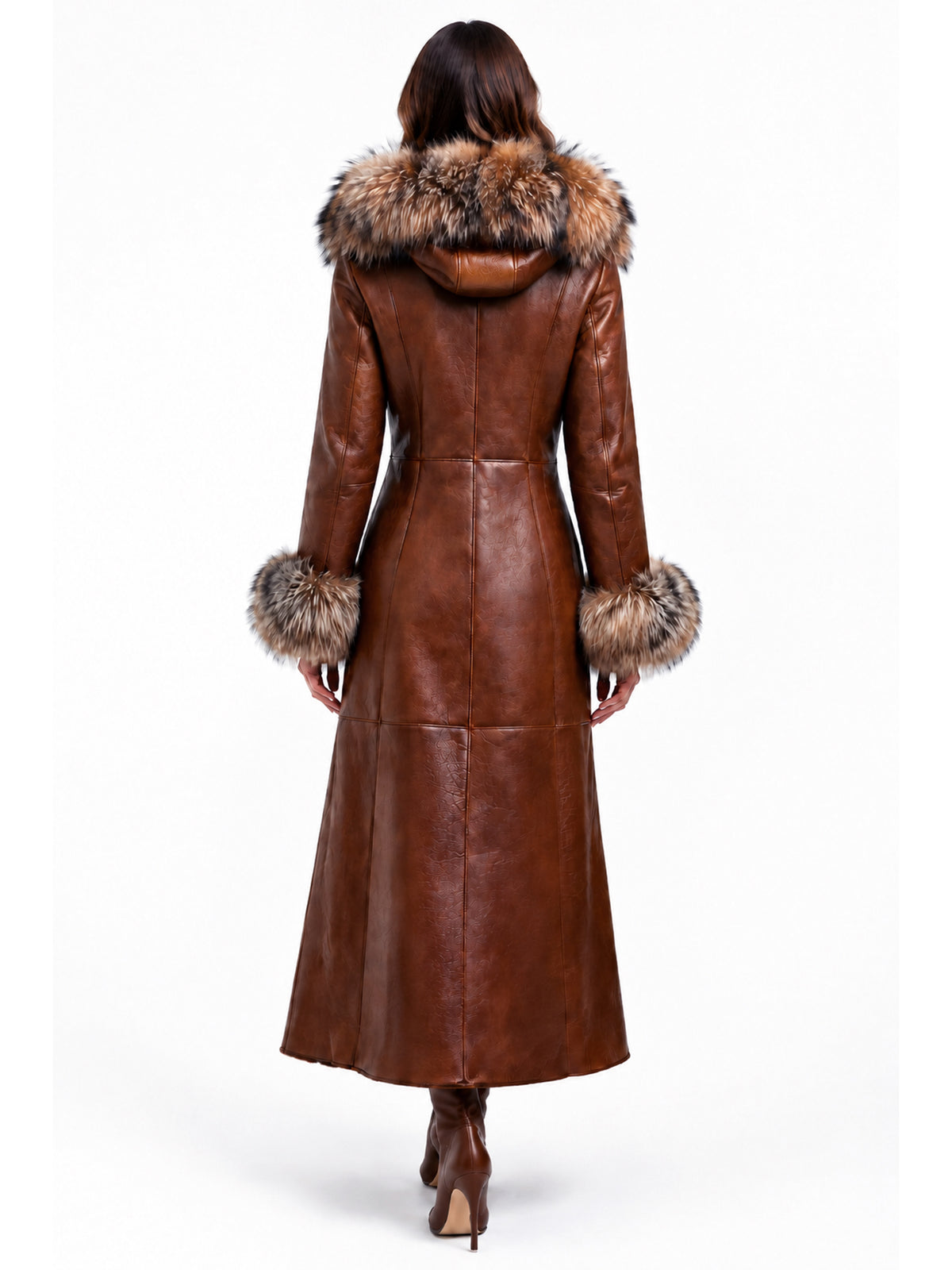 A woman viewed from the back wearing a long brown sheepskin shearling leather coat with a large brown fur hood trim and matching fur-trimmed cuffs, paired with brown ankle boots, against a plain white background.