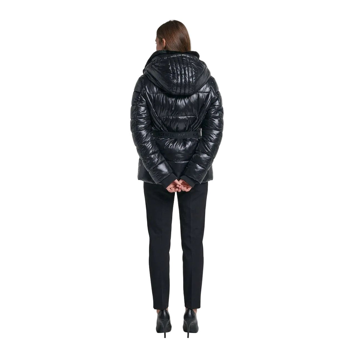 A woman shown from the back wearing a shiny black puffer jacket with a fur-trimmed hood and a matching black belt