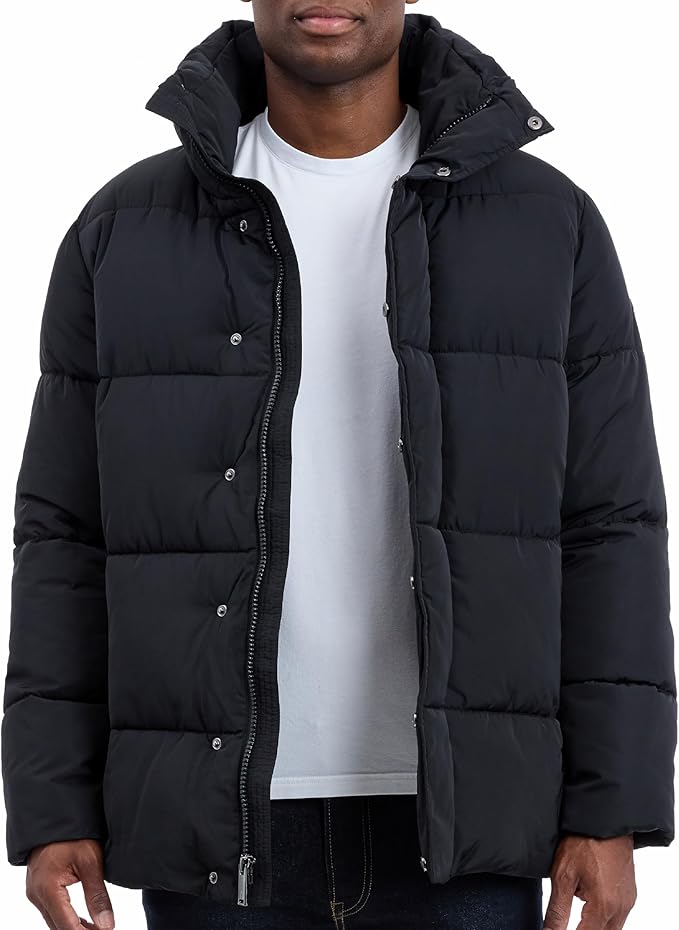 Person wearing a black puffer jacket over a white shirt on a white background
