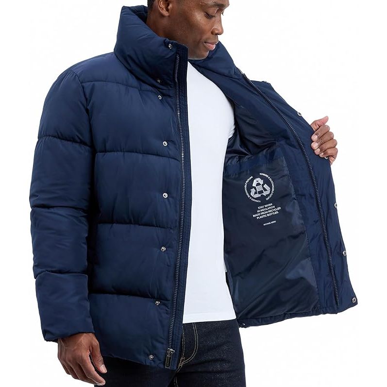Man wearing a navy blue puffer jacket with a visible brand logo on a white background