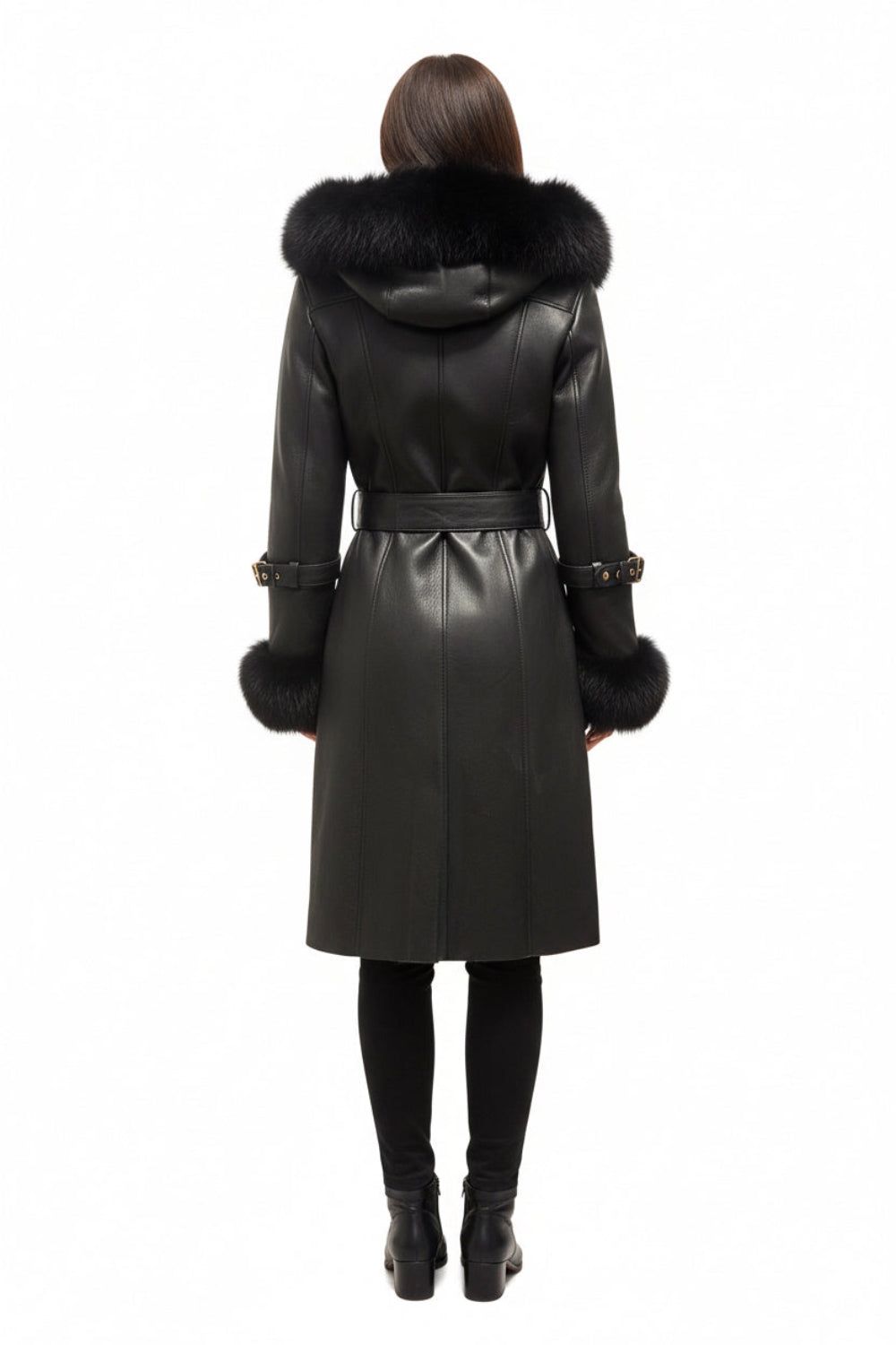 A woman viewed from the back wearing a black sheepskin leather coat with a large black fur-trimmed hood and matching fur-trimmed cuffs, paired with black tights and black boots, against a plain white background.